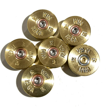 Seven gold Winchester AA 12 gauge shotgun shell headstamps arranged in a cluster, showing ‘WIN AA HS 12 GA’ stampings