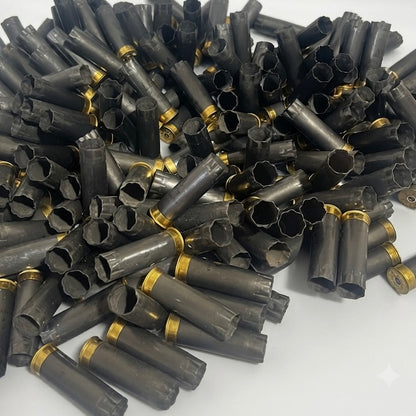Bulk mound of spent gray Winchester AA 12 gauge shotgun shells on a white background.