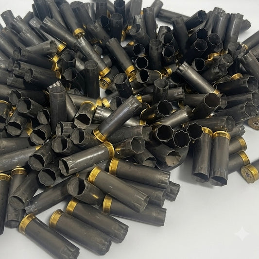 Bulk mound of spent gray Winchester AA 12 gauge shotgun shells on a white background.