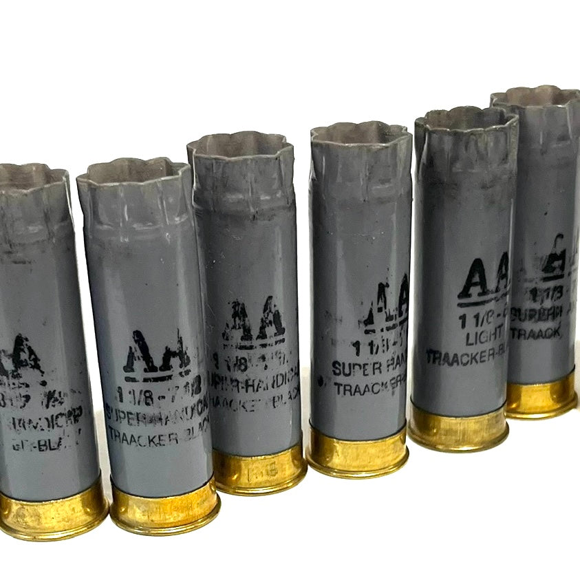 Row of light gray Winchester AA 12 gauge shotgun shells with gold bases showing printed hull markings