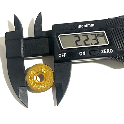 A gold brass slice sits beside a digital caliper displaying a 22.3 mm diameter reading.