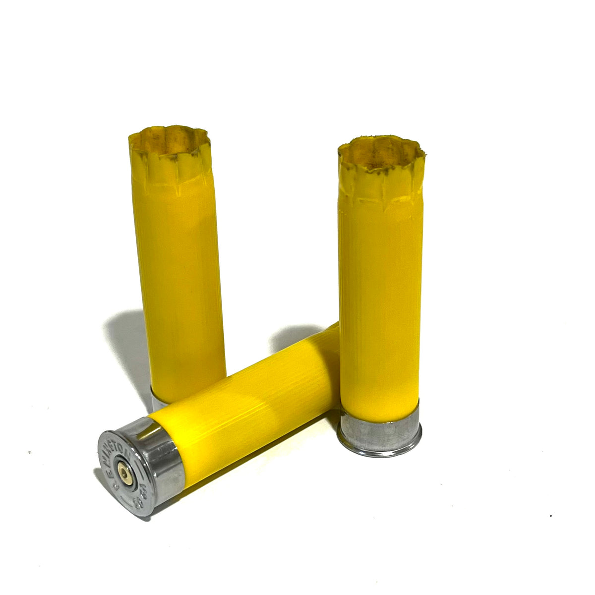 3 yellow shotgun shells, 2 standing and 1 lying, showing silver headstamp base on a white background