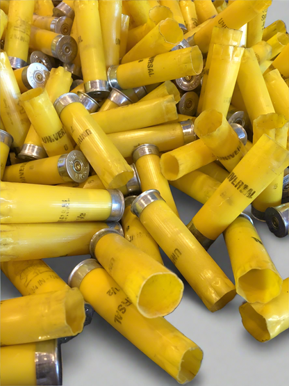A large pile of yellow shotgun shell hulls with silver bottoms