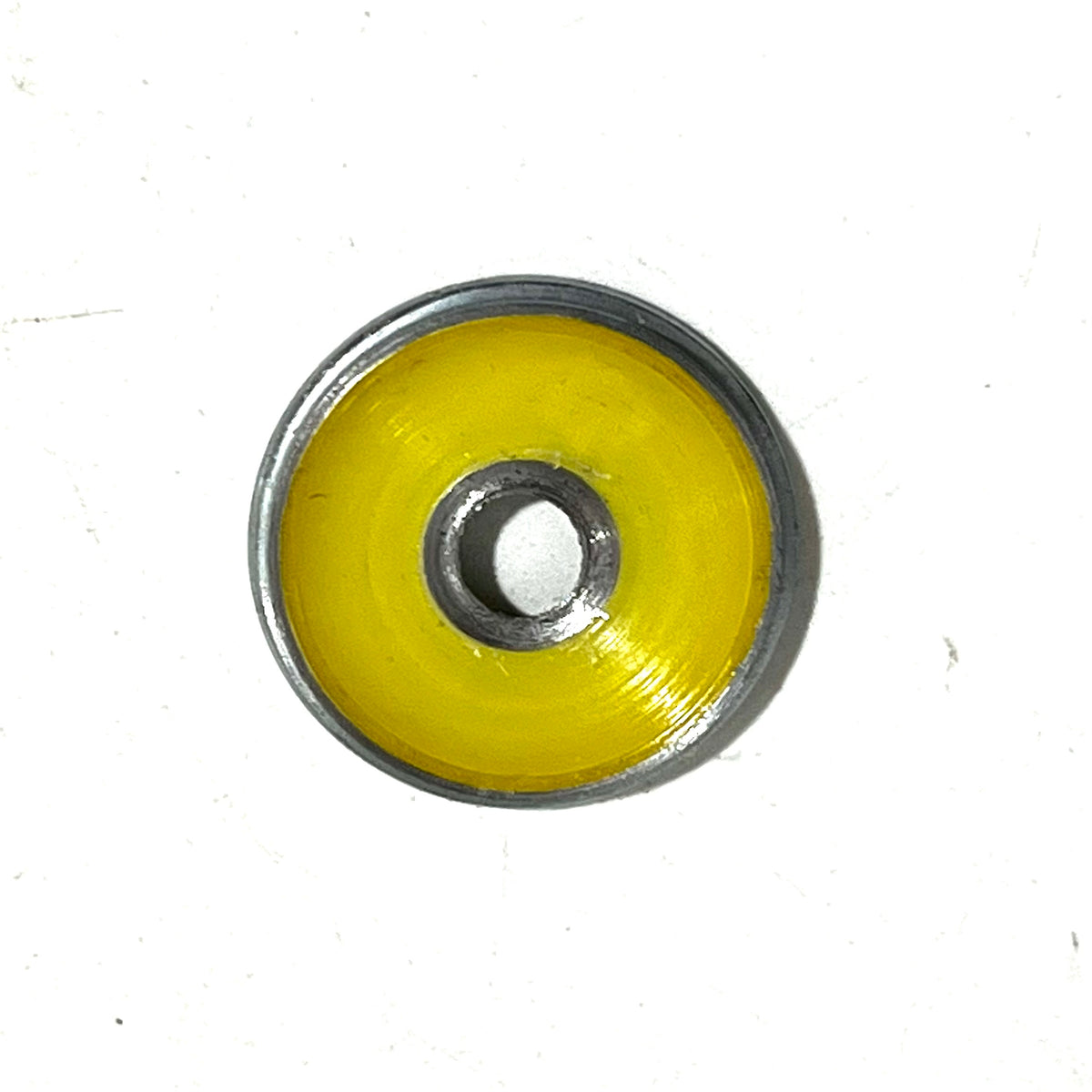 Yellow-painted Winchester 20 GA shotgun shell slice on a white background