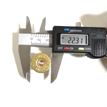 Digital caliper measuring the outer diameter of a 12 gauge shell headstamp slice showing 22.31 mm