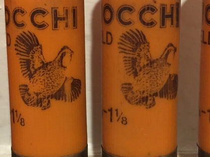 Macro close-up of orange 12 gauge shotshell casings showing black printed flying pheasant artwork and text.