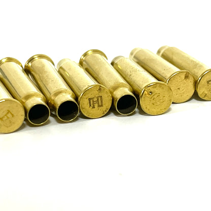 Six empty .17 HMR brass cartridge casings lined up in a row on a white background.