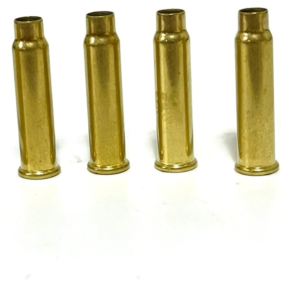 Four empty .17 HMR brass cartridge cases standing upright in a horizontal row on a plain white background.