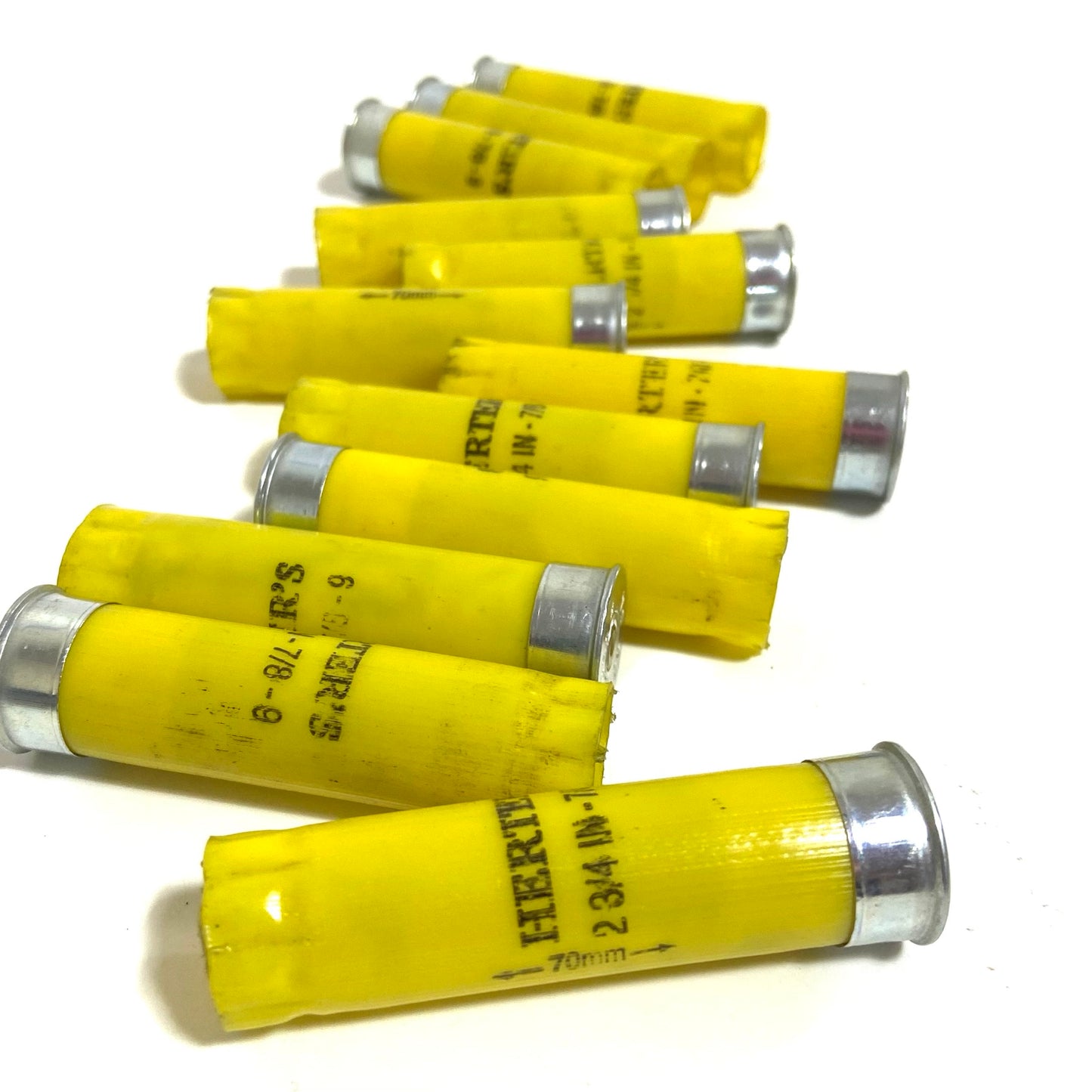 Ten Herter's 20 gauge yellow shotgun shell hulls fanned out