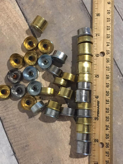 Detail of 20 gauge casing slices with stamped manufacturer markings ruler comparison.
