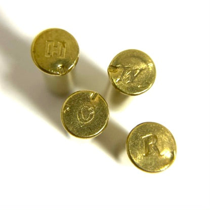 Four .22 WMR brass headstamps showing distinct manufacturer caliber markings on base rims.