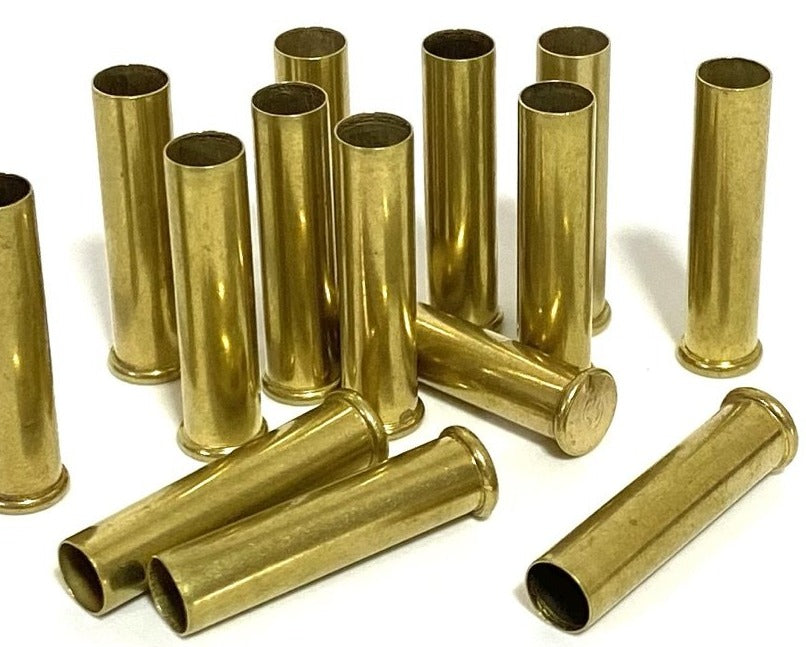 Eleven .22 WMR brass casings with eight standing upright and three resting horizontally in front.