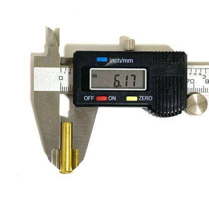 Stainless steel digital caliper measuring outer diameter of a .22 WMR brass shell showing 6.17 mm on display.