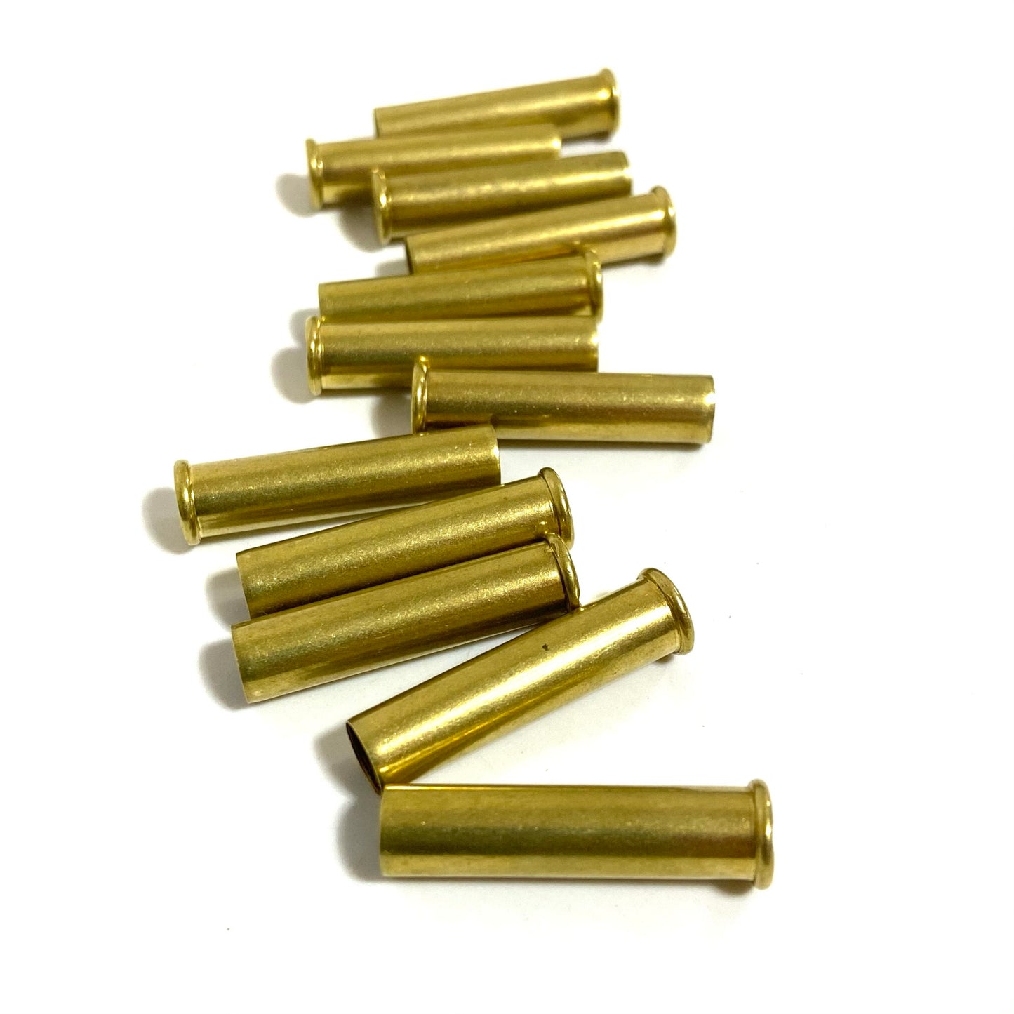 Stacked cluster of shiny yellow .22 WMR brass shells lying horizontally on a white background.