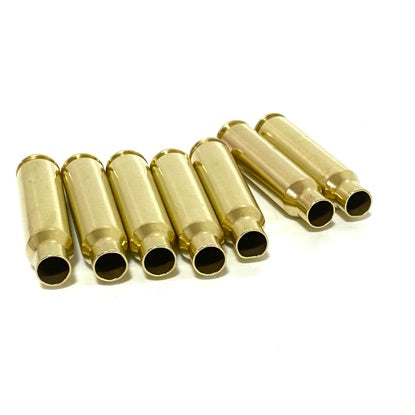 Eight polished 223 brass shells lined up in a row with empty round case mouths facing forward.