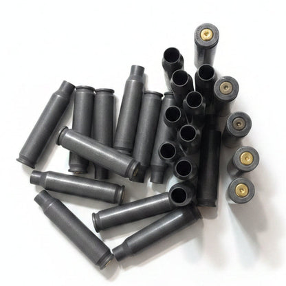 A cluster of used gray steel casings shows some standing upright with primers and others lying open.