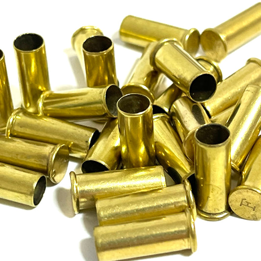Close-up pile of empty .22LR brass casings with headstamps visible