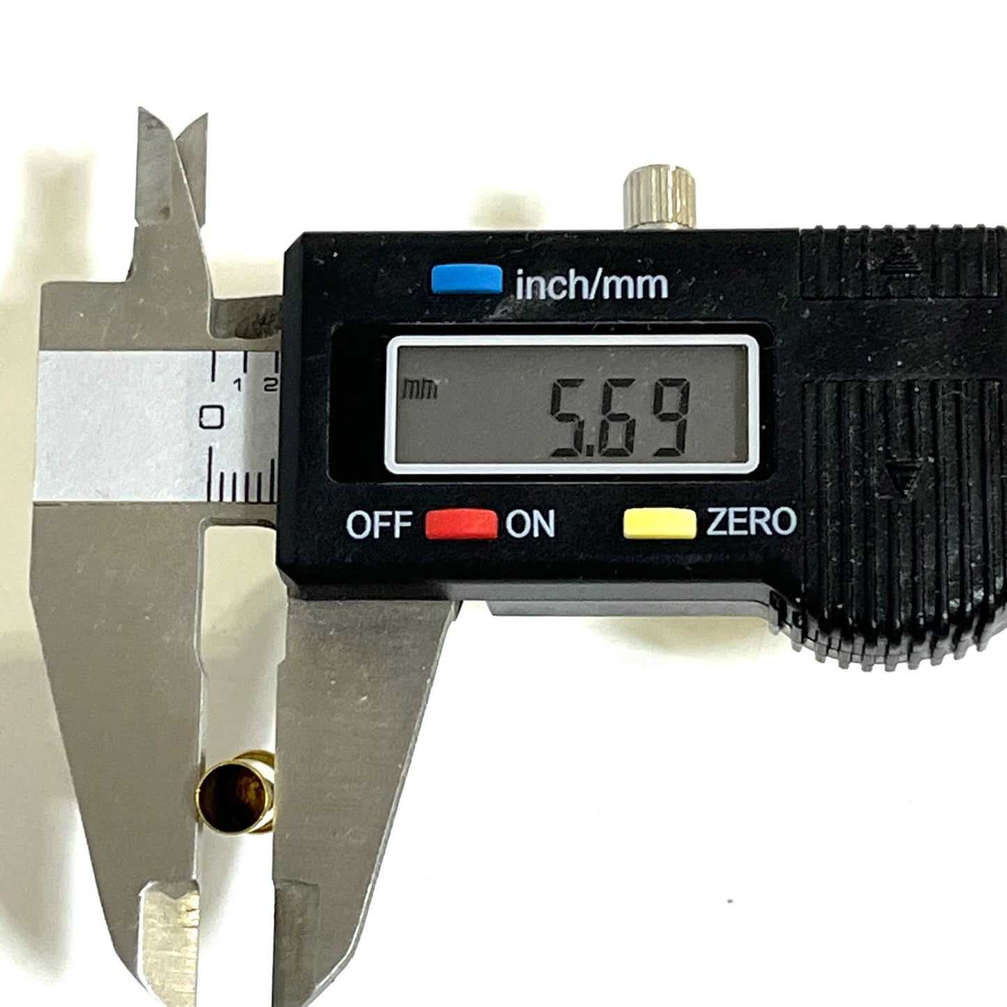 Digital caliper measuring the head diameter of an inert .22LR brass casing at 5.69 mm