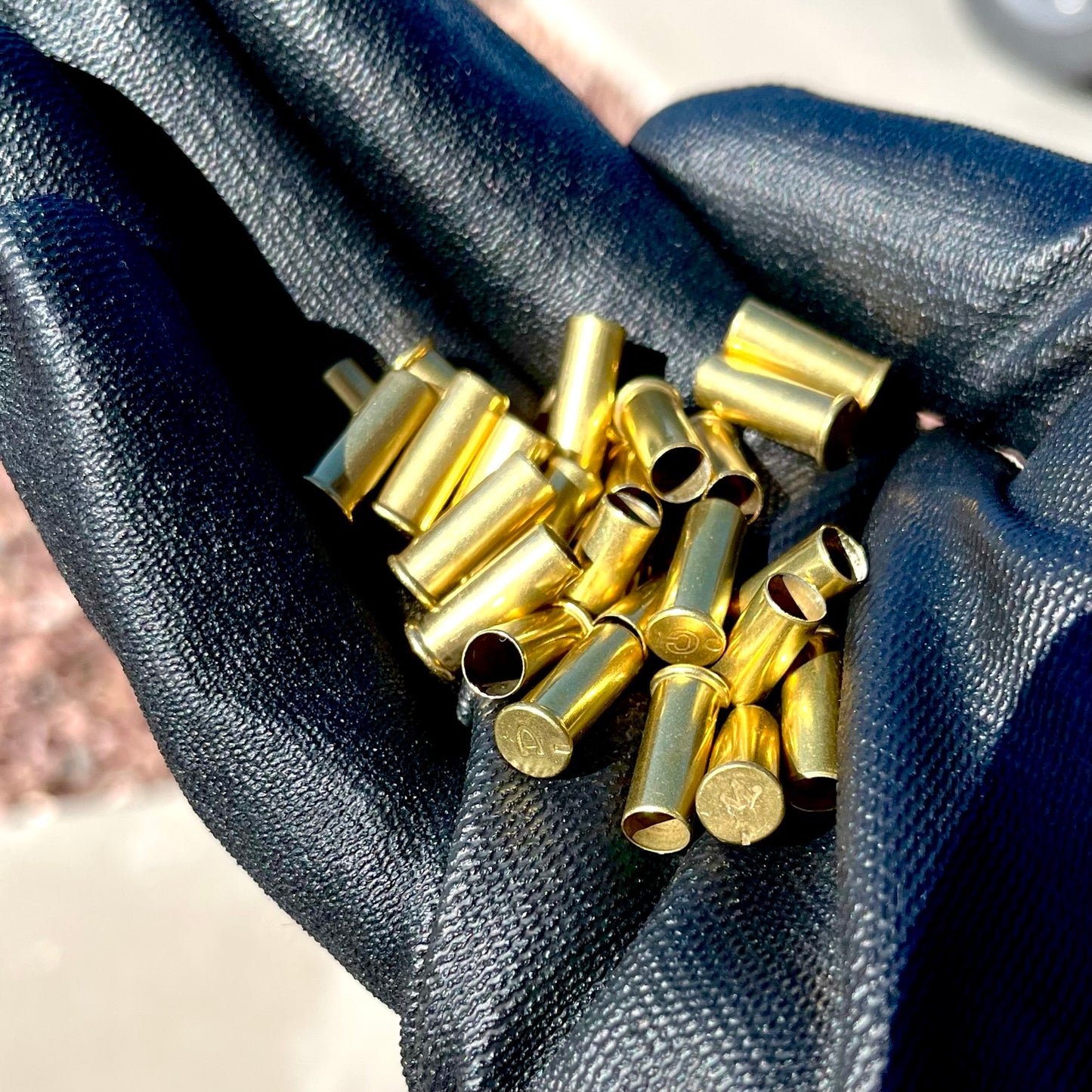 Handful of once-fired .22LR brass casings held in cloth