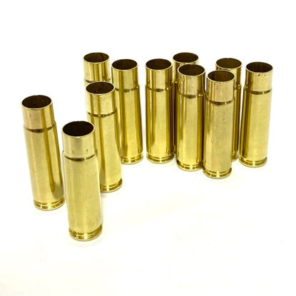 A cluster of empty 300 Blackout brass rifle casings standing upright on a pure white background.