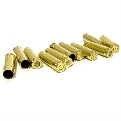 A line of empty 300 Blackout rifle brass shells positioned horizontally against a plain white backdrop.