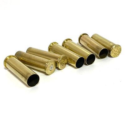 Six brass .357 Magnum shell casings lying at an angle with open mouths facing forward on a white background