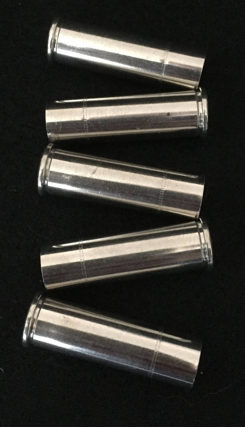 Five nickel 357 Magnum empty shell casings arranged in a zigzag row on a black background