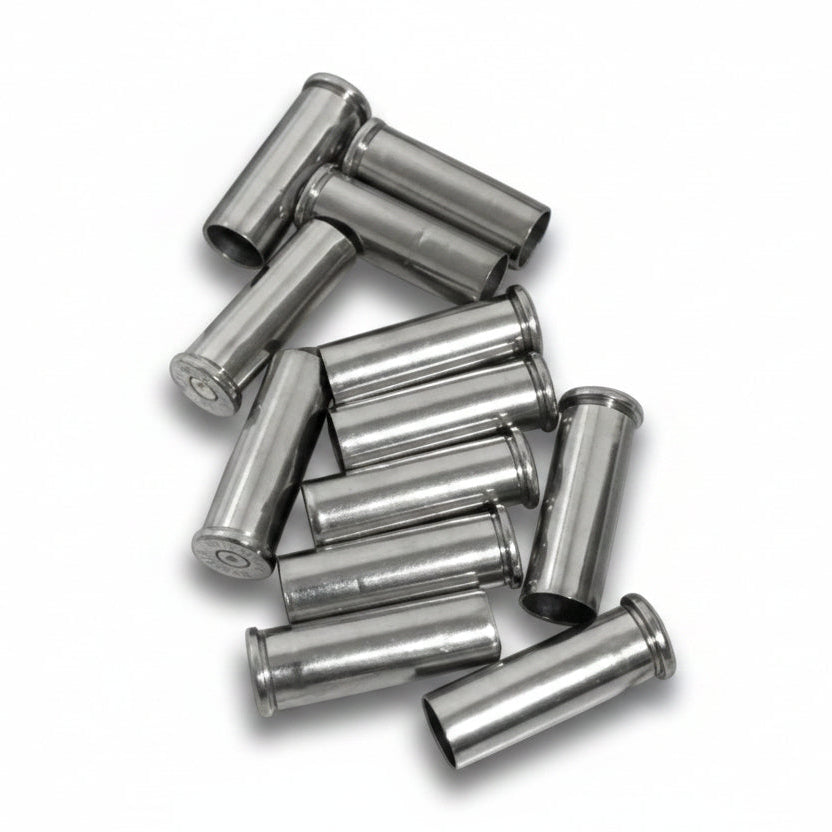 A tightly clustered heap of used silver nickel shells resting on a weathered wood-plank surface.