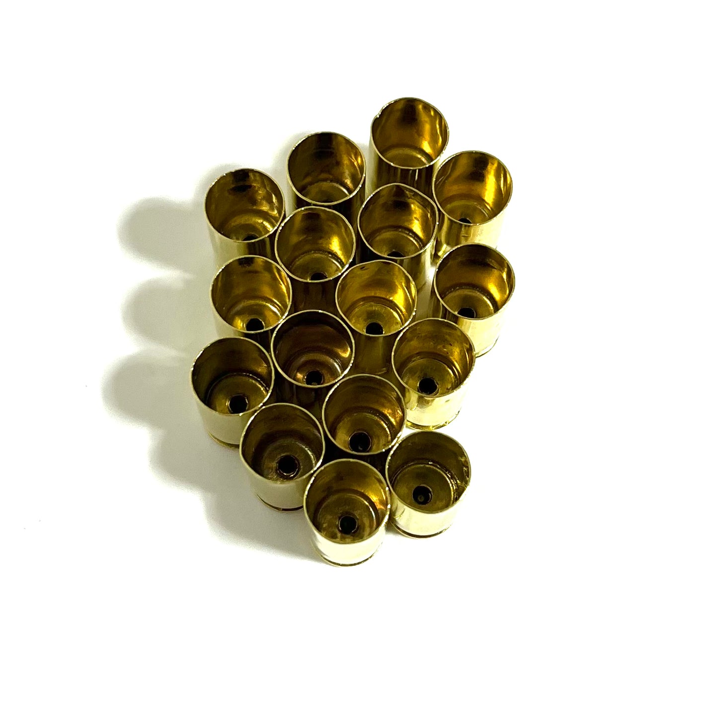 Empty .380 Auto brass casings arranged in a tight grid, open mouth facing up