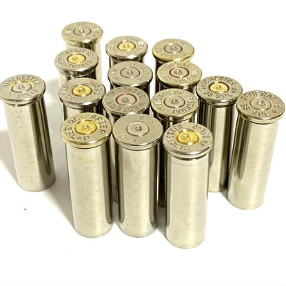 A cluster of empty silver nickel 38 special cartridge cases standing upright with visible 38 Special headstamps.