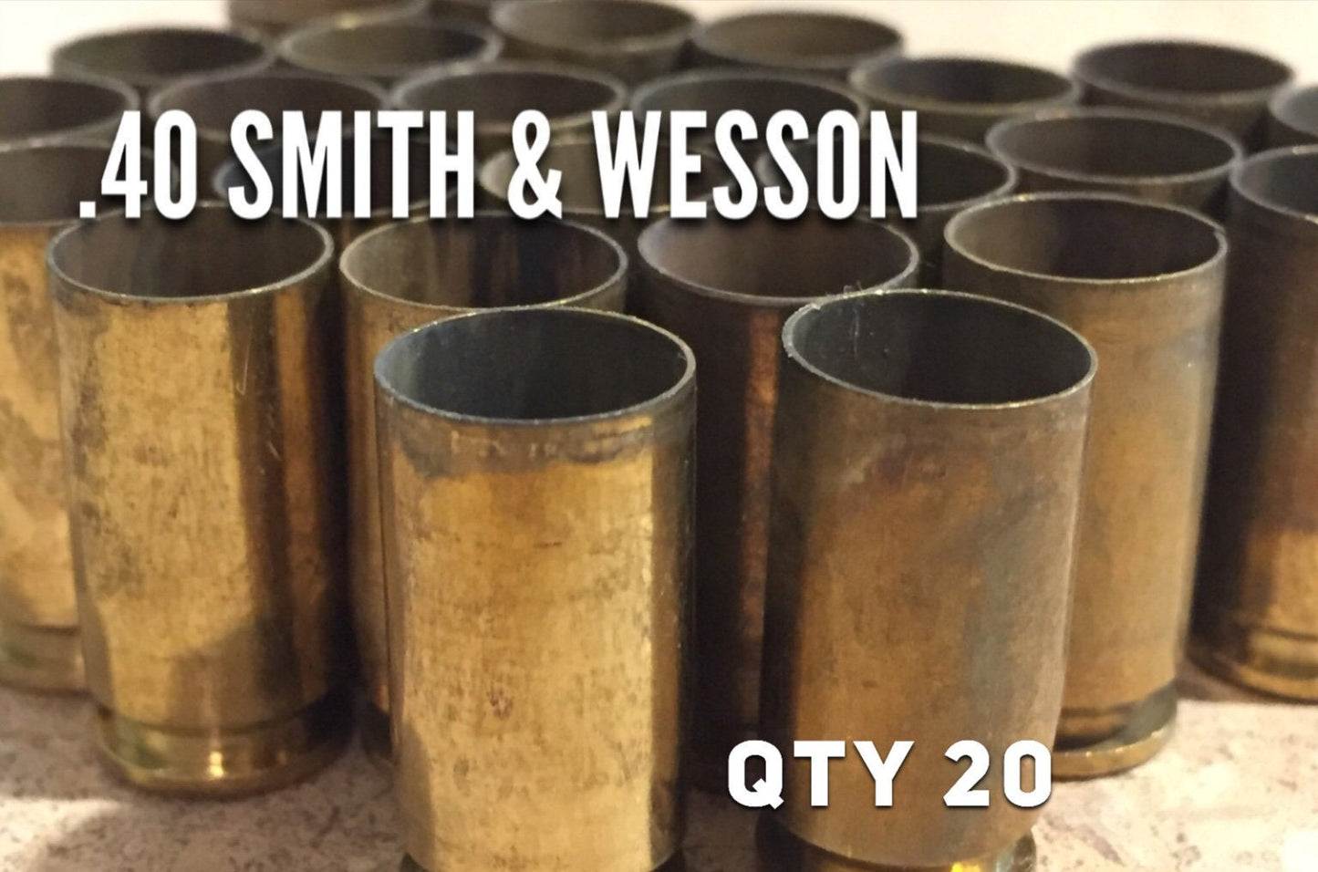 40 caliber spent brass casings with text quantity 20 and .40 S&W on white surface