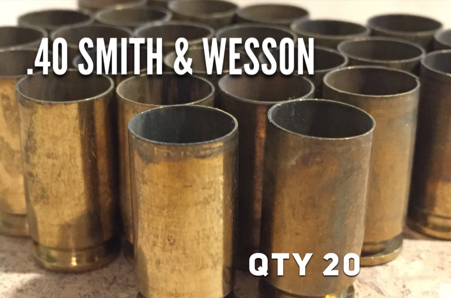 40 caliber spent brass casings with text quantity 20 and .40 S&W on white surface