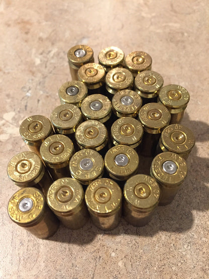 Cluster of gold .40 S&W brass casings viewed from above, showing headstamp markings and spent silver primers