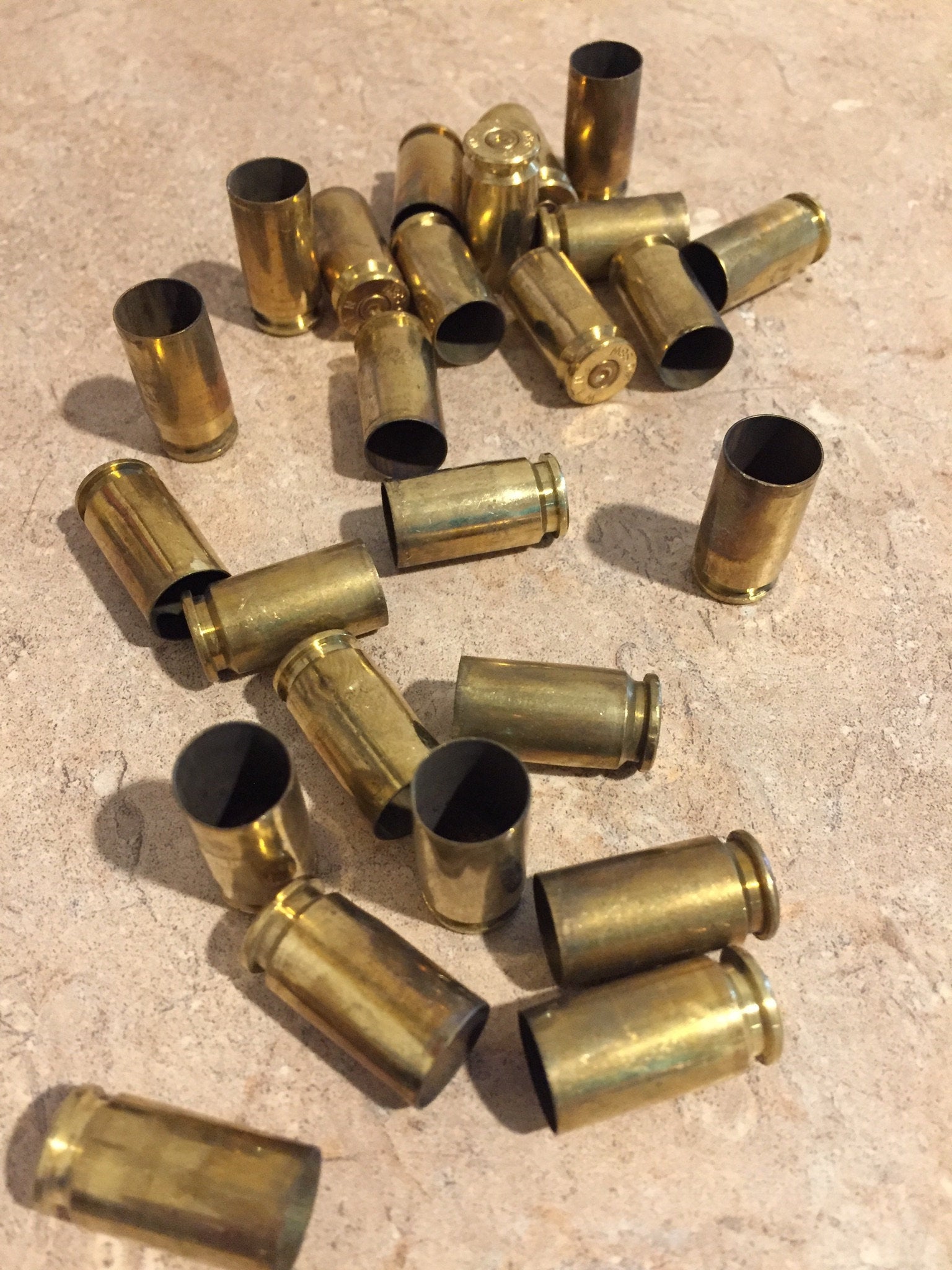 Pile of gold .40 S&W brass casings lying at angles, showing open mouths