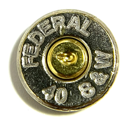 A single polished 40 S&W nickel bullet slice on a white surface, featuring a clearly legible FEDERAL 40 S&W headstamp and a spent brass primer.