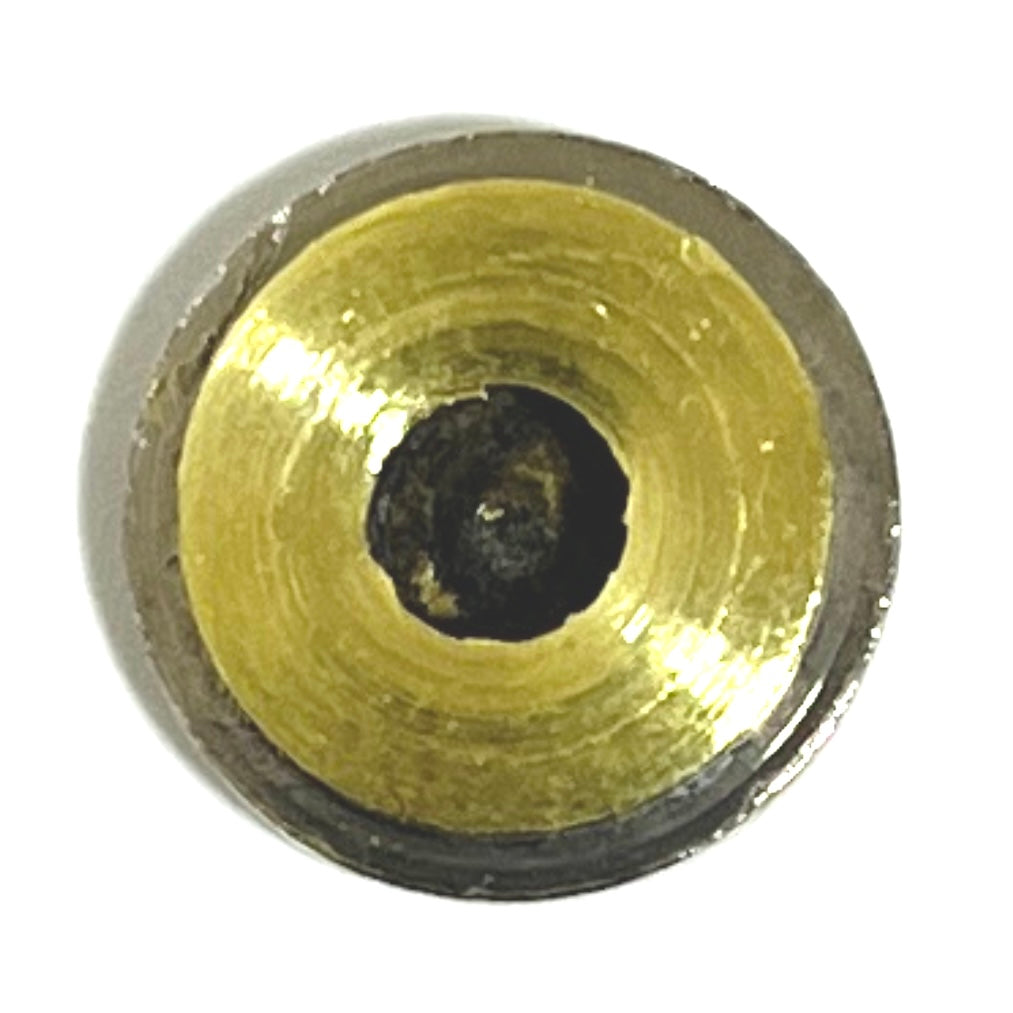 A macro close-up of a single polished 40 S&W nickel bullet slice with smooth edges on a white surface, focusing on the silver outer rim and the contrasting brass-colored center with a dark spent primer.
