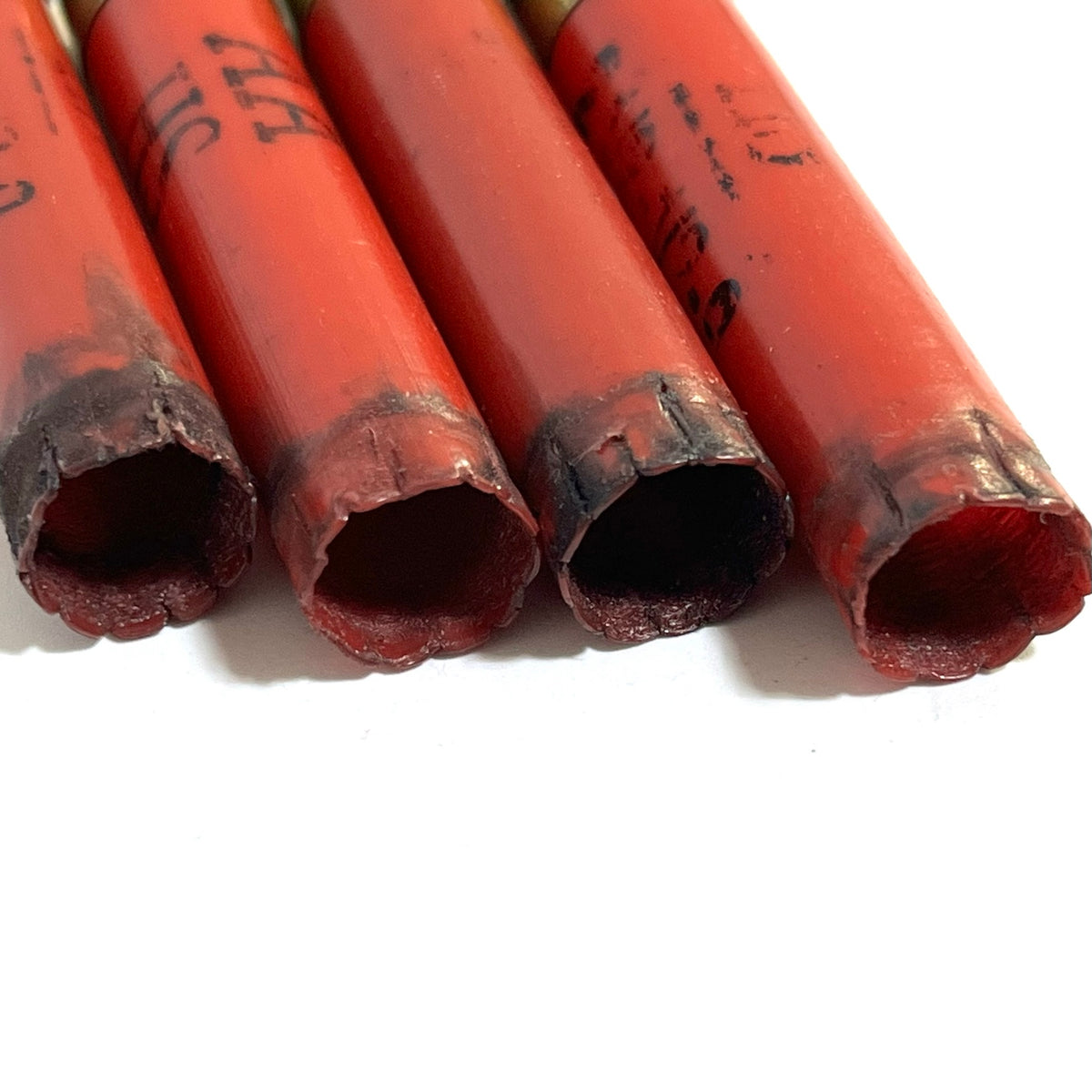 Close-up of the open ends of 4 red Winchester AA 410 bore shotgun shell hulls