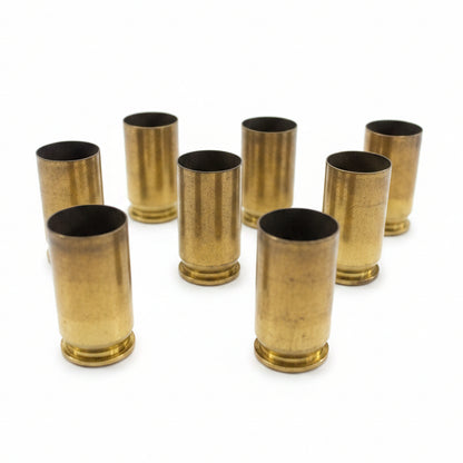 7 brass .45 ACP casings standing upright in staggered rows on white background, open mouths facing up