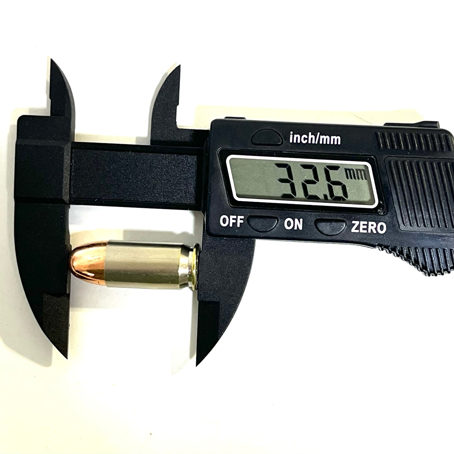 A single nickel 45 ACP dummy round measured lengthwise with a black digital caliper showing 32.6 mm.