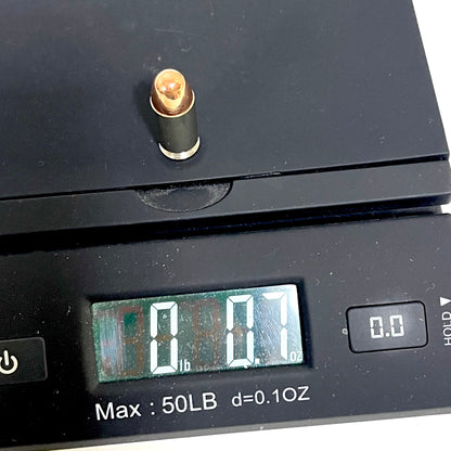A single nickel 45 ACP dummy round placed on a digital scale, displaying a weight of 0.7 ounces.