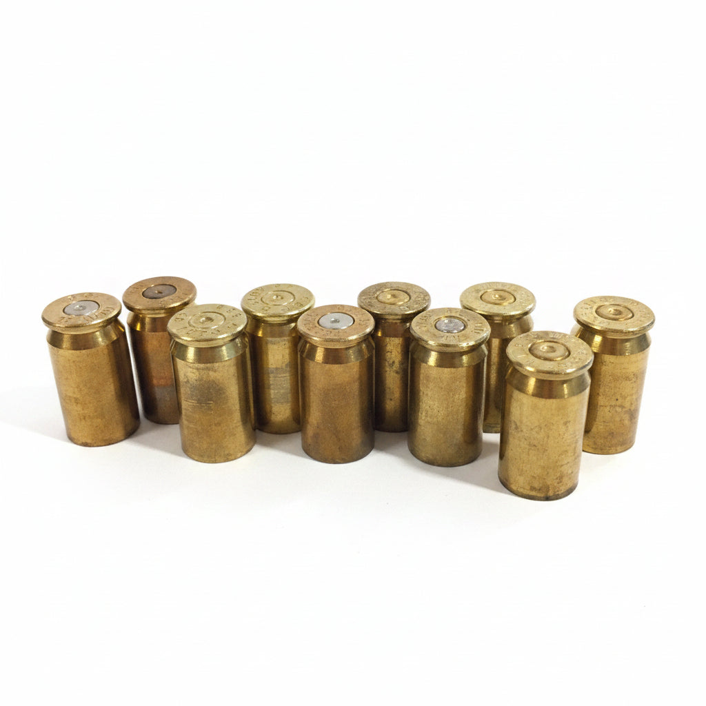 10 brass .45 ACP casings standing upright in a loose cluster on white background, primer ends facing up