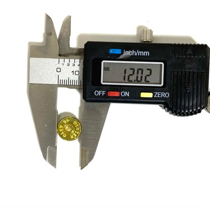 Digital caliper measuring the diameter of a gold brass slice, display reading 12.02mm.
