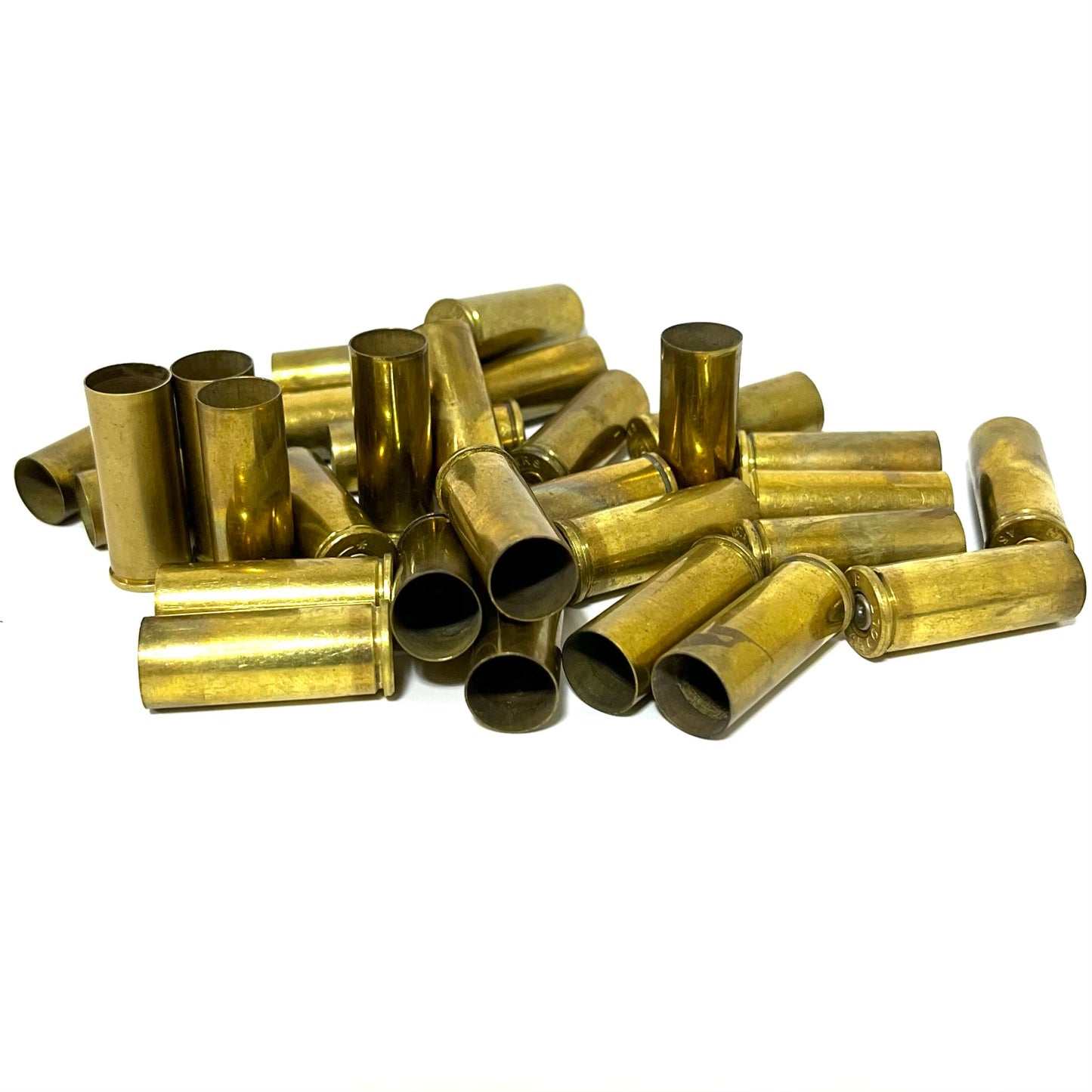 Pile of gold .45 Colt brass casings on a white background, showing open mouths