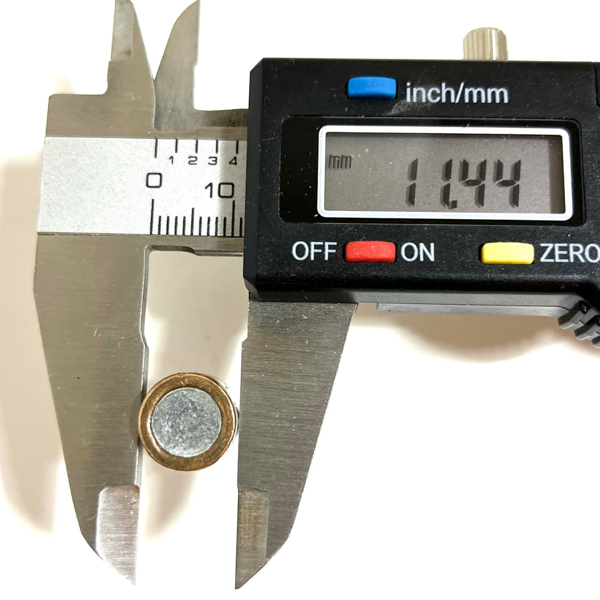 Digital caliper measuring the diameter of a fired 45 ACP bullet showing 11.44 mm