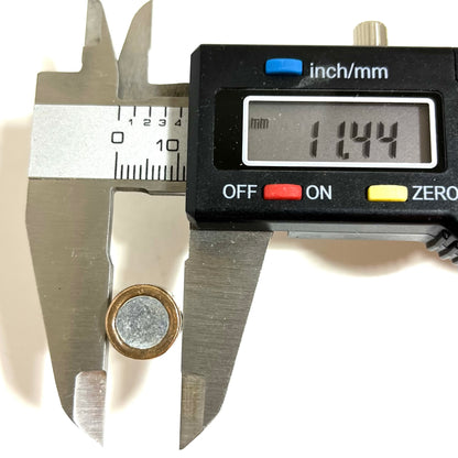 Digital caliper measuring the diameter of a fired 45 ACP bullet showing 11.44 mm