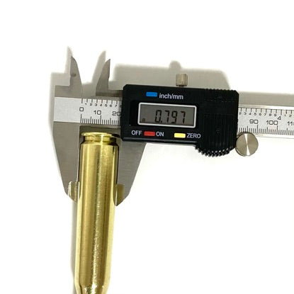 A 50 BMG paperweight base being measured with a digital caliper showing 0.797 inches on a white background.