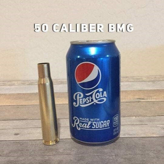 50 Caliber BMG polished once fired brass next to Pepsi can for size reference.