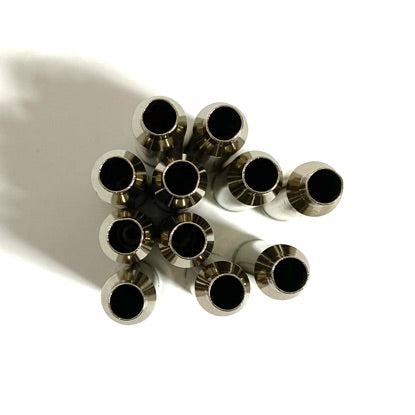 Top view looking down into the open necks of several empty nickel-plated 7mm Remington Magnum spent rifle shell casings.

