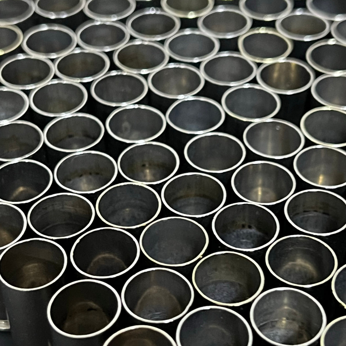 Rows of empty nickel 9mm casings viewed from above showing open mouths