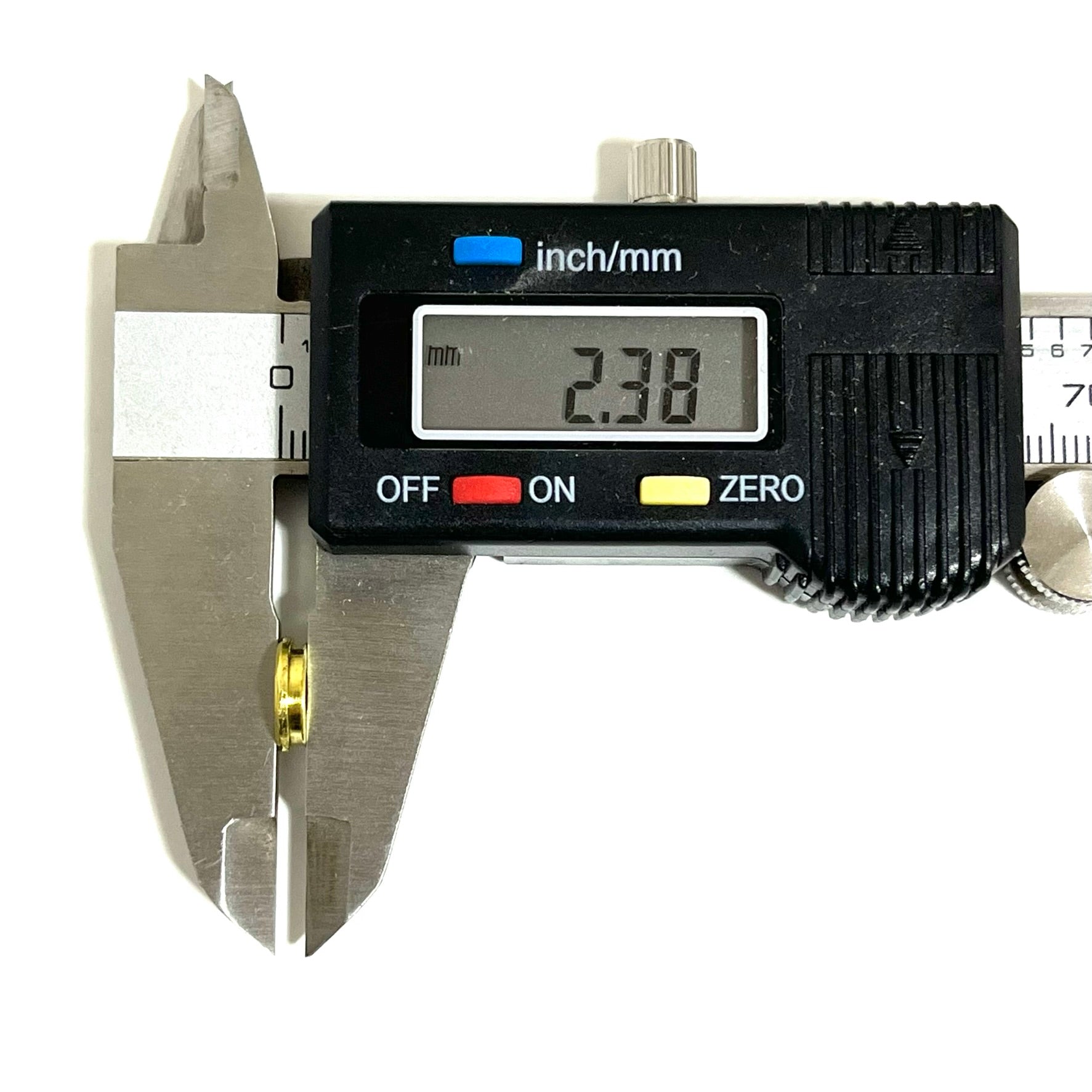 A digital caliper reads 2.38 mm while measuring the thickness of a 9mm deprimed brass slice.
